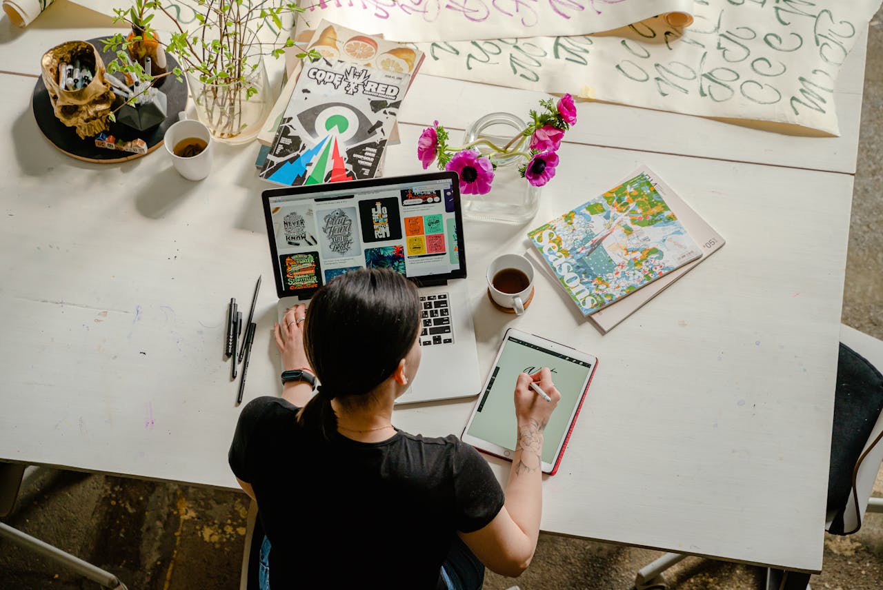 featured-portfolio-02 Artistic workspace featuring calligraphy and digital design on a tablet and laptop.