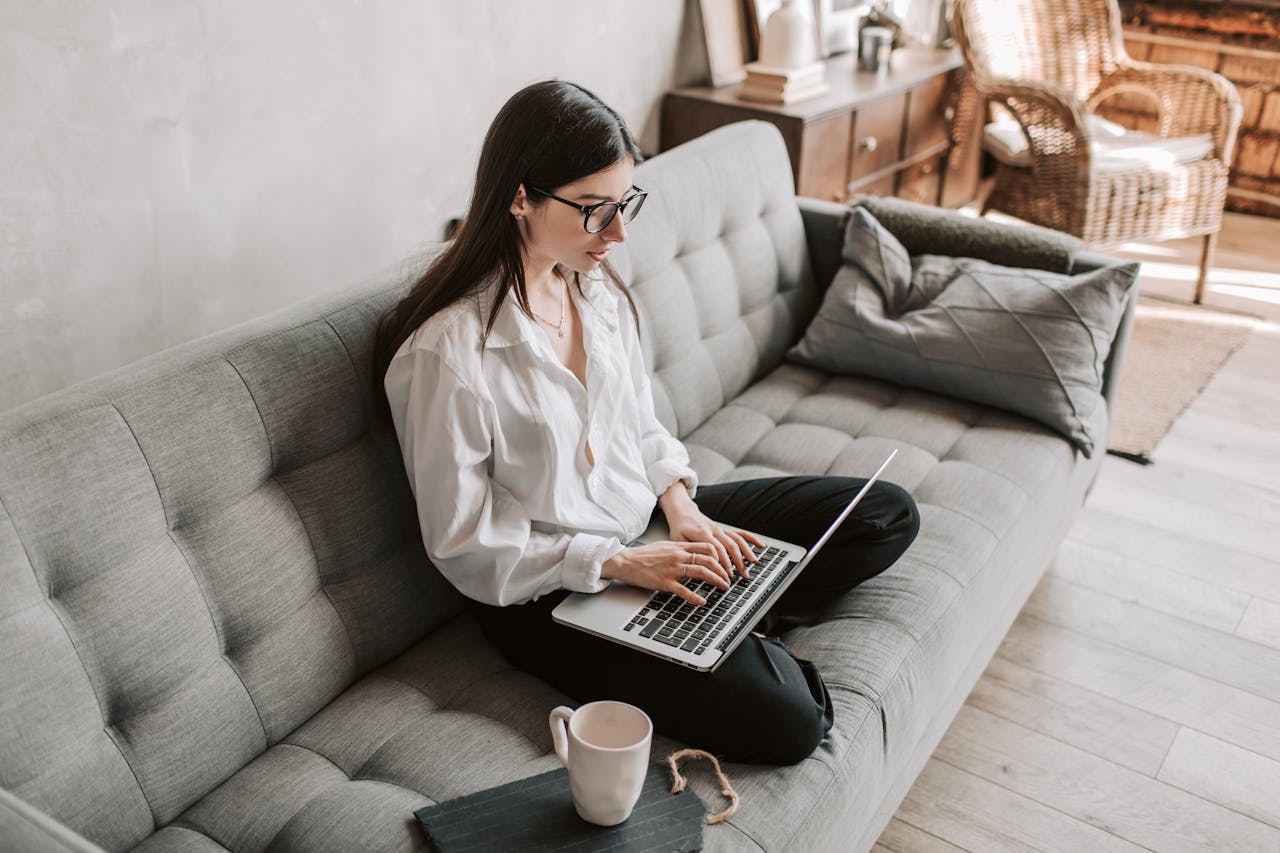 featured-portfolio-03 Woman in a cozy home setting working on a laptop for remote work and relaxation.